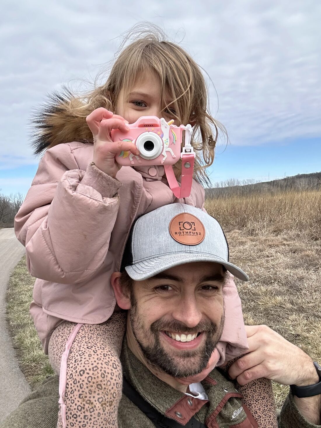 John Rothfusz with his daughter, who is holding up her own toy camera